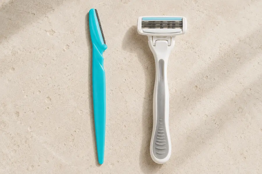 A fine facial razor beside a bulkier body razor for comparison